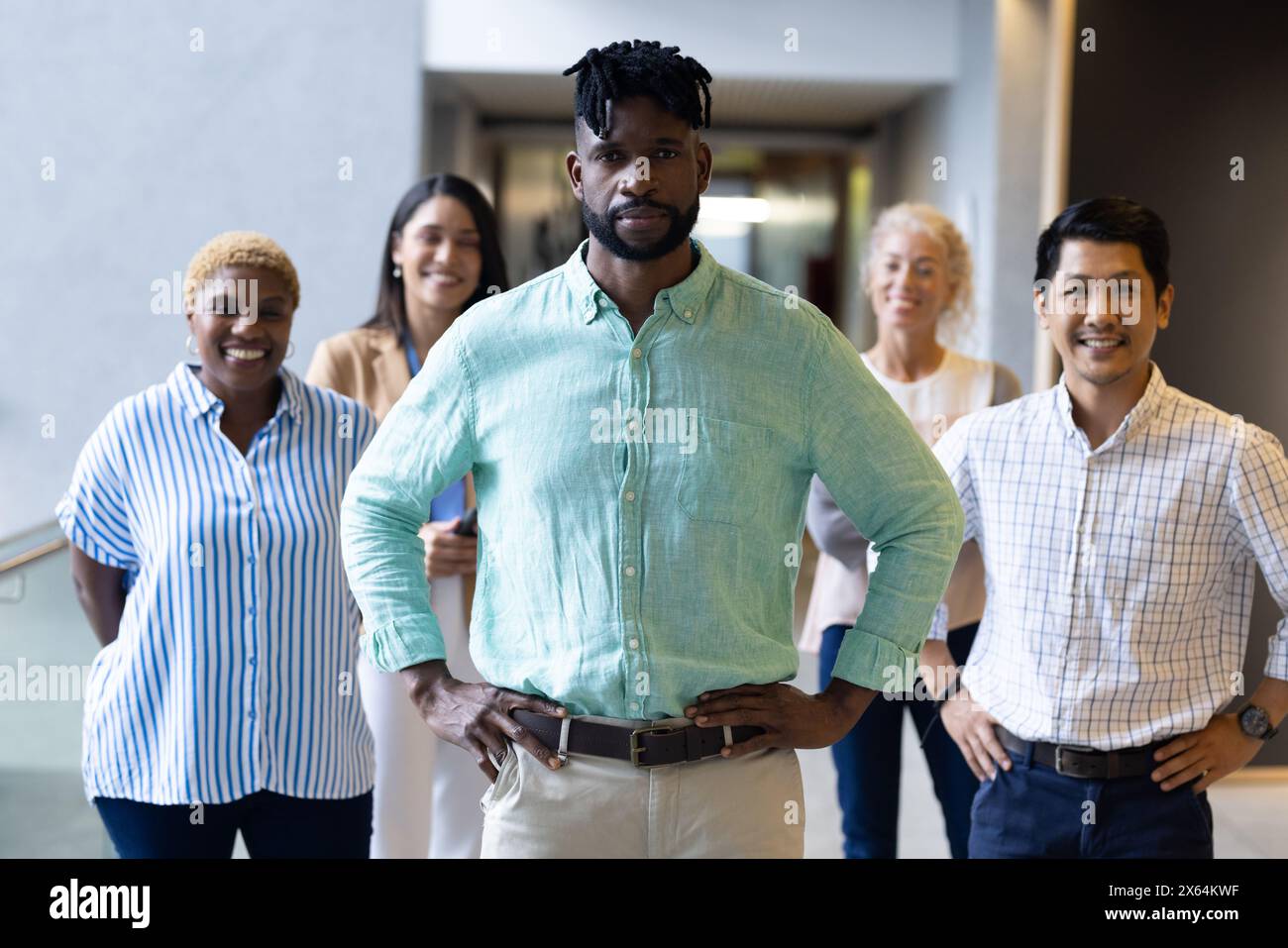 Ein vielfältiges Team, das zusammen im Büro steht und alle lächelt Stockfoto