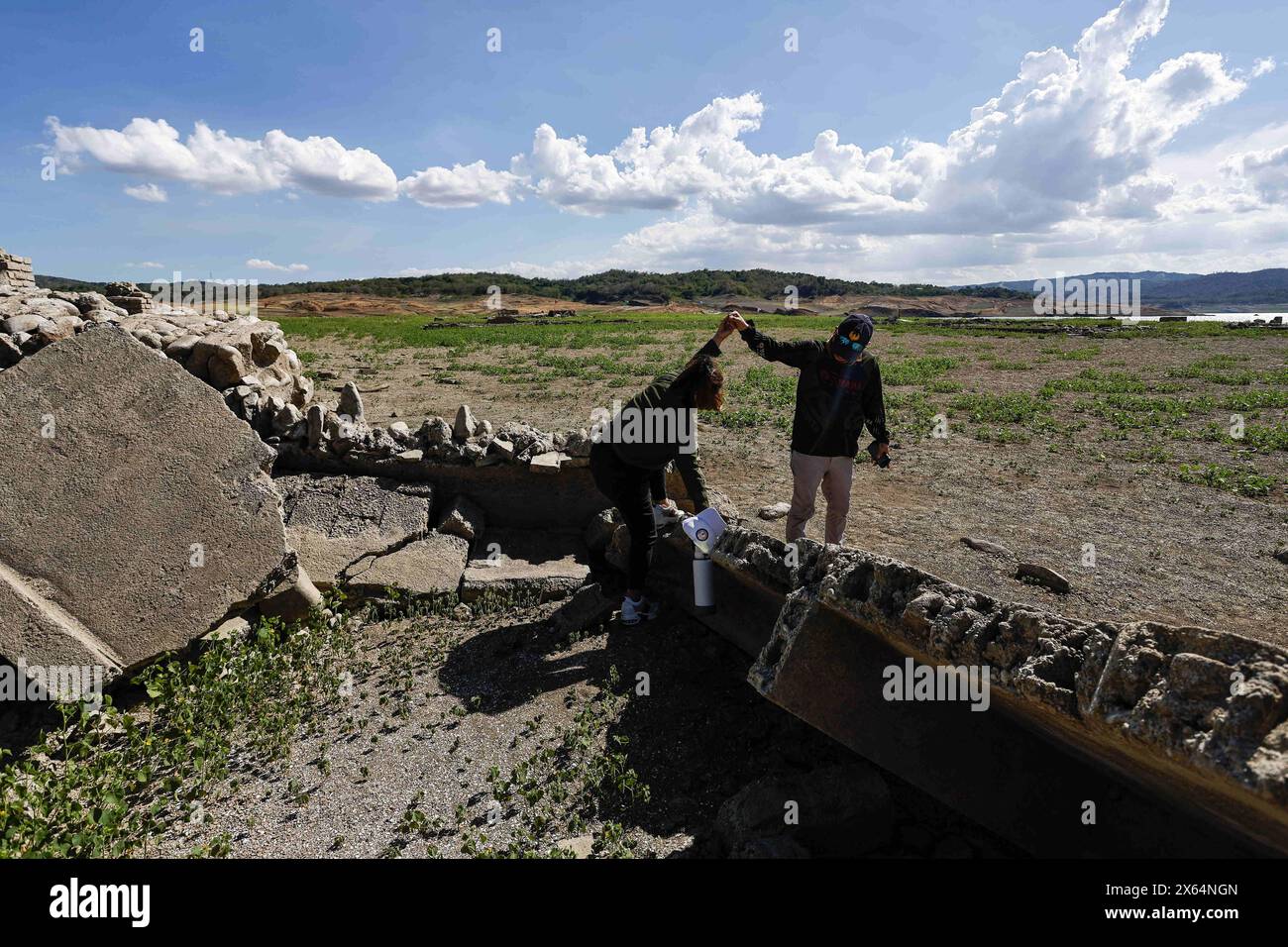 12. Mai 2024, Pantabangan, Pantabangan, Philippinen: Touristen besuchen die Überreste der alten versunkenen Stadt Pantabangan, die infolge einer schweren Dürre aufgrund der steigenden Temperaturen auf den Philippinen an einem Stausee wieder aufgetaucht sind. Das sechste Wiederauftauchen dieser 300 Jahre alten Siedlung, die eine Kirche und mehrere Grabsteine umfasst, hat Touristen zu Besuch gezogen, nachdem der Wasserstand am Damm durch extreme Hitze abgenommen hat. verschärft durch die El-NiÃ±-o-Klimamuster, die zu einer Zunahme des Wetters in Asien und Südostasien beitragen. (Bild: © Daniel Ceng Shou Stockfoto