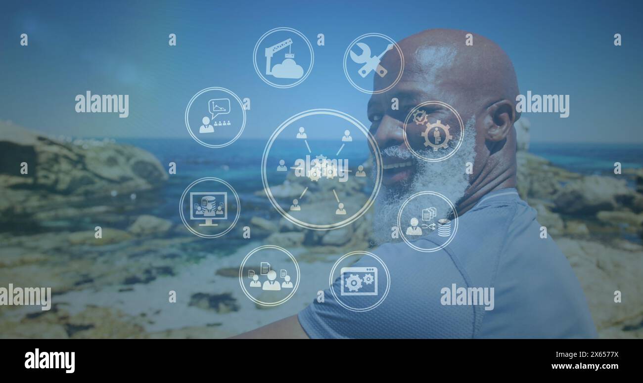 Bild von Medienikonen über lächelndem afroamerikaner am Strand Stockfoto