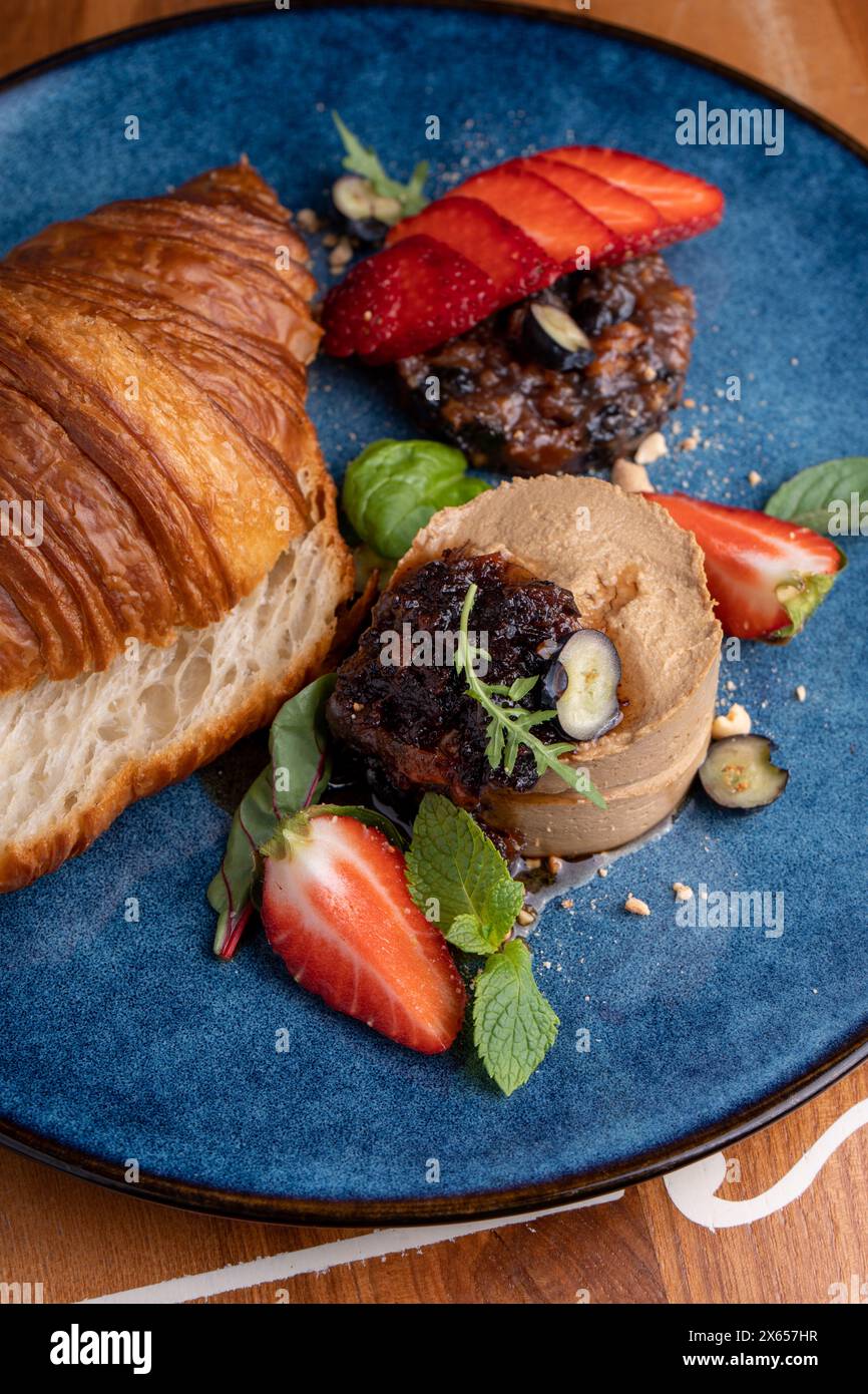 Frisch gebackenes Croissant mit Leberpastete, leckere Gourmet-Vorspeise auf dem Tisch Stockfoto