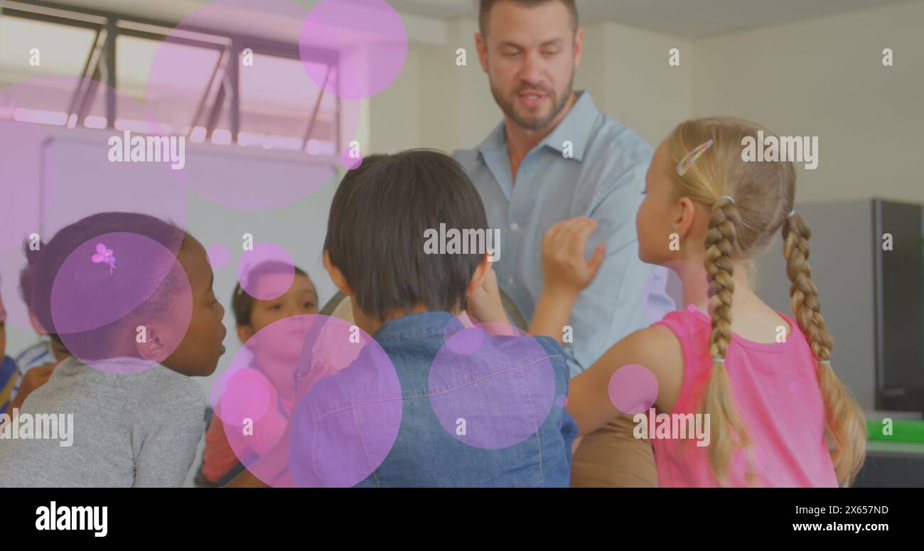 Bild von leuchtendem Licht über verschiedenen Schulkindern mit männlichem Lehrer im Klassenzimmer Stockfoto