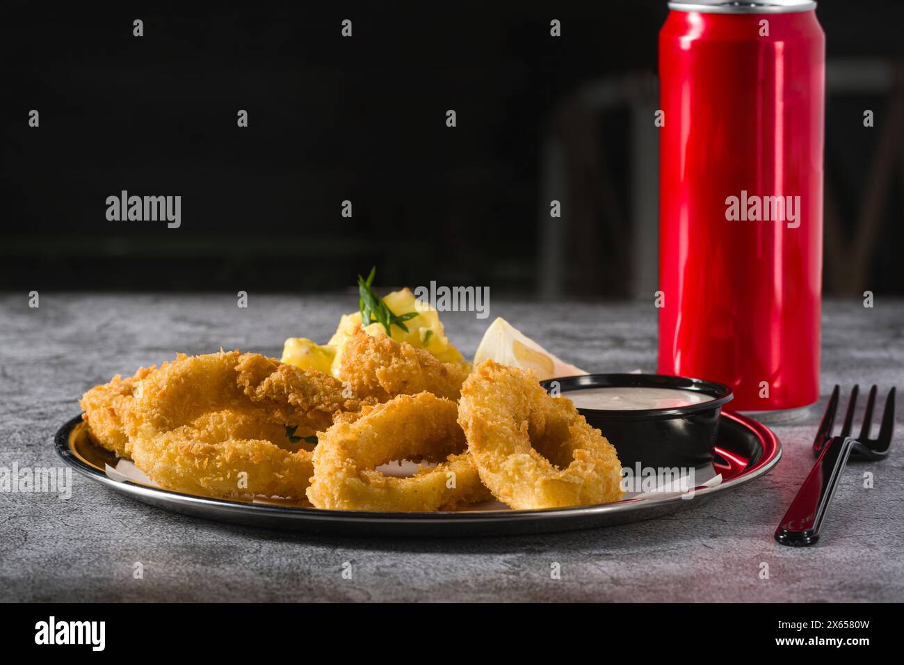 Gebratene Calamari mit Kartoffelsalat daneben auf Steintisch Stockfoto