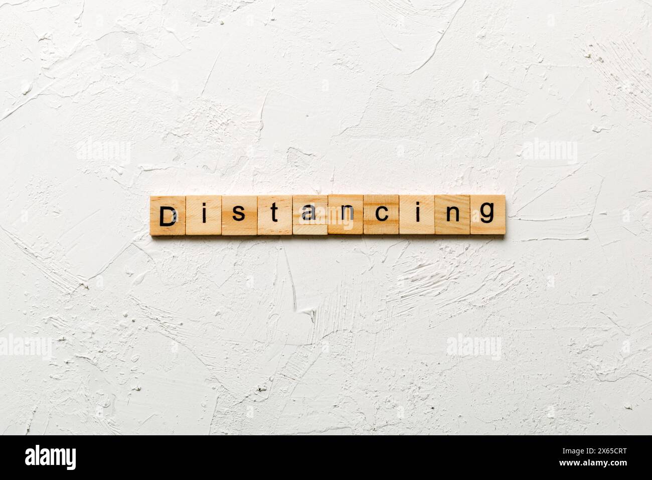 Distanzierungsswort auf Holzblock geschrieben. Distanzierungstext auf Zementtisch für Ihr Design, Konzept. Stockfoto