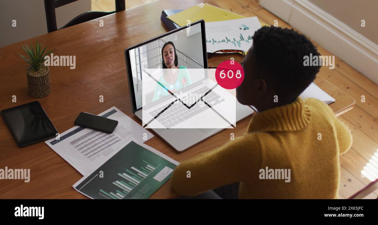 Bild des Postsymbols und der Zahlen über afroamerikanischer Geschäftsfrau mit Laptop Stockfoto