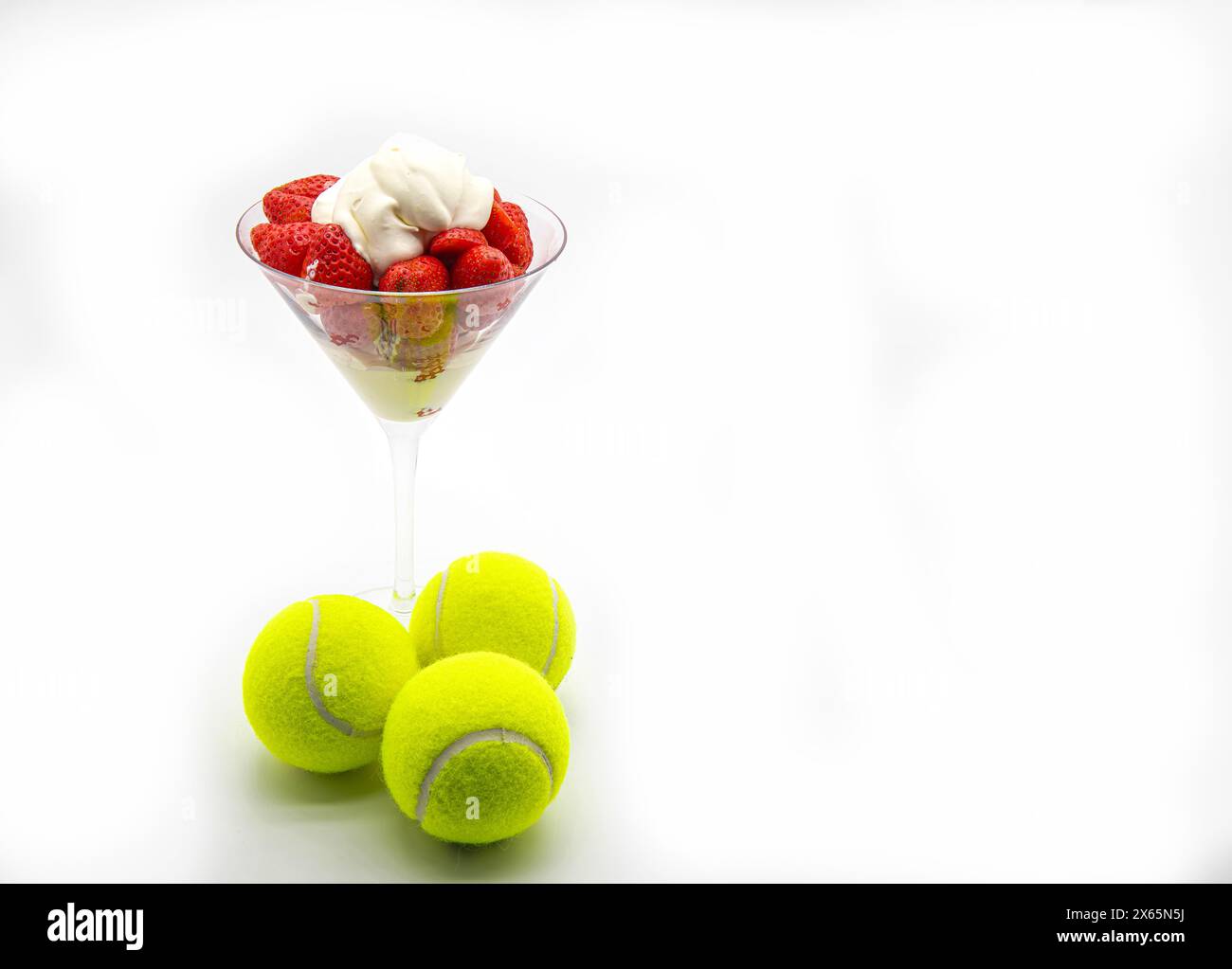 Erdbeeren und Creme in einer Glasschale isoliert auf weißem Hintergrund. Stockfoto