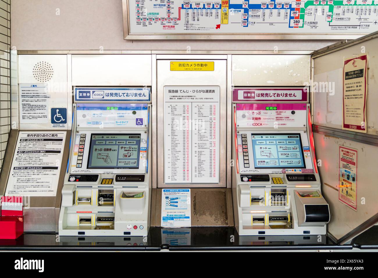 Zwei zweisprachige (Japanisch und Englisch) Bahnfahrkartenautomaten nebeneinander vor dem Hankyu Bahnhof in Shukugawa, Nishinomiya. Stockfoto