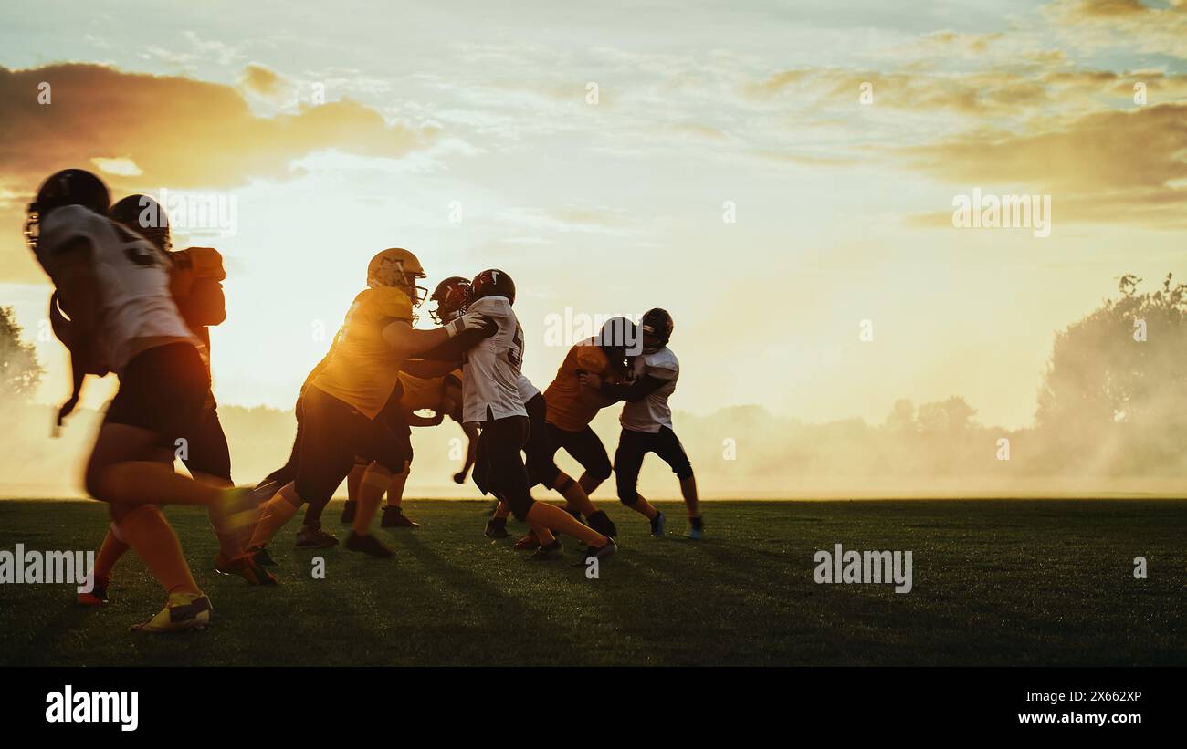 American Football Field zwei Teams konkurrieren: Spieler bestehen und laufen angreifend, um Touchdown-Punkte zu erzielen. Profisportler kämpfen um den Ball, Tackle. Dramatische Goldene Stunde Stockfoto