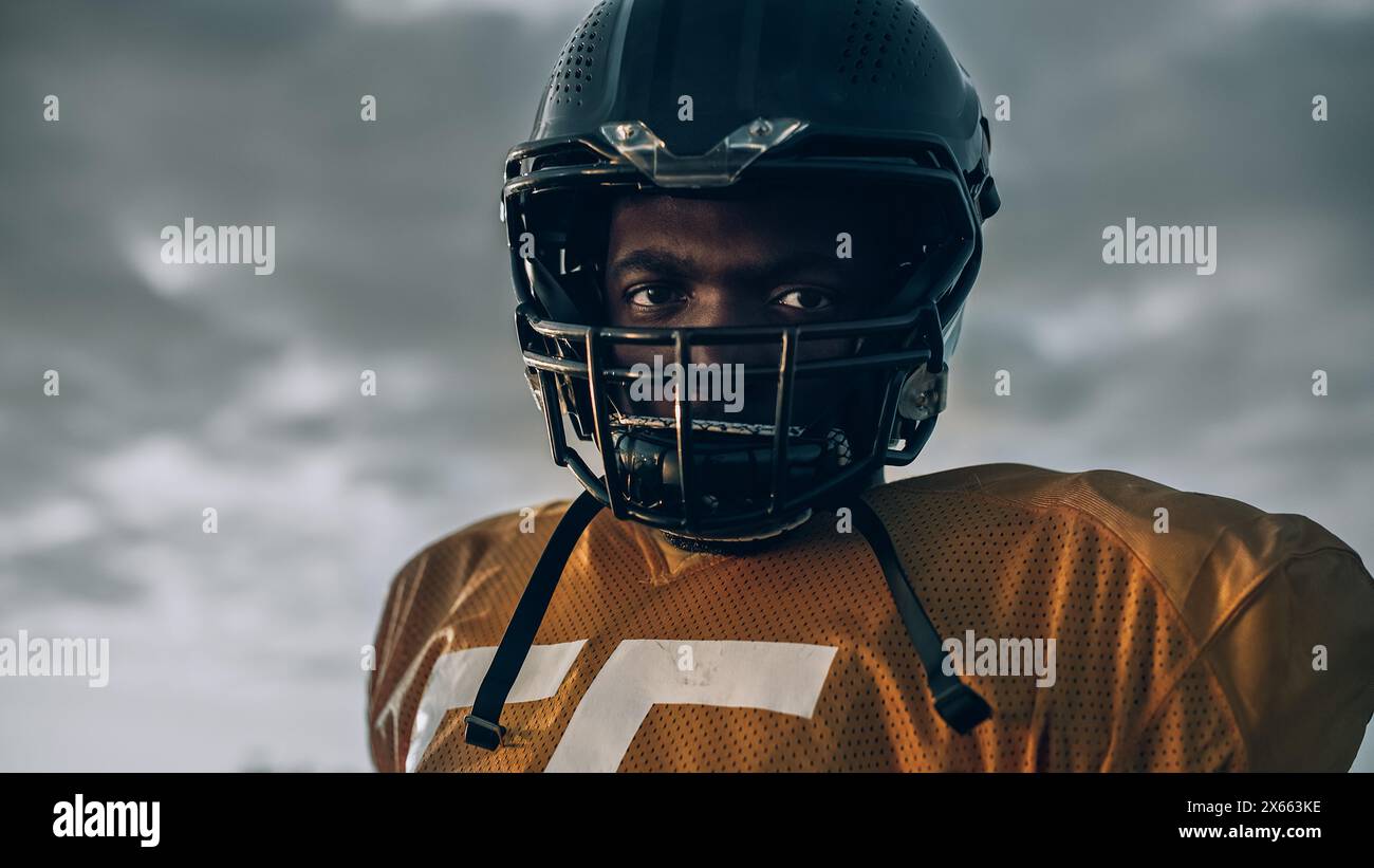 American Football Championship Game: Nahaufnahme Porträt eines professionellen Spielers, der Helm trägt. Profi-Athlet voller Kraft, Geschick, Entschlossenheit zu gewinnen. Aufnahmen Mit Niedrigem Winkel Stockfoto