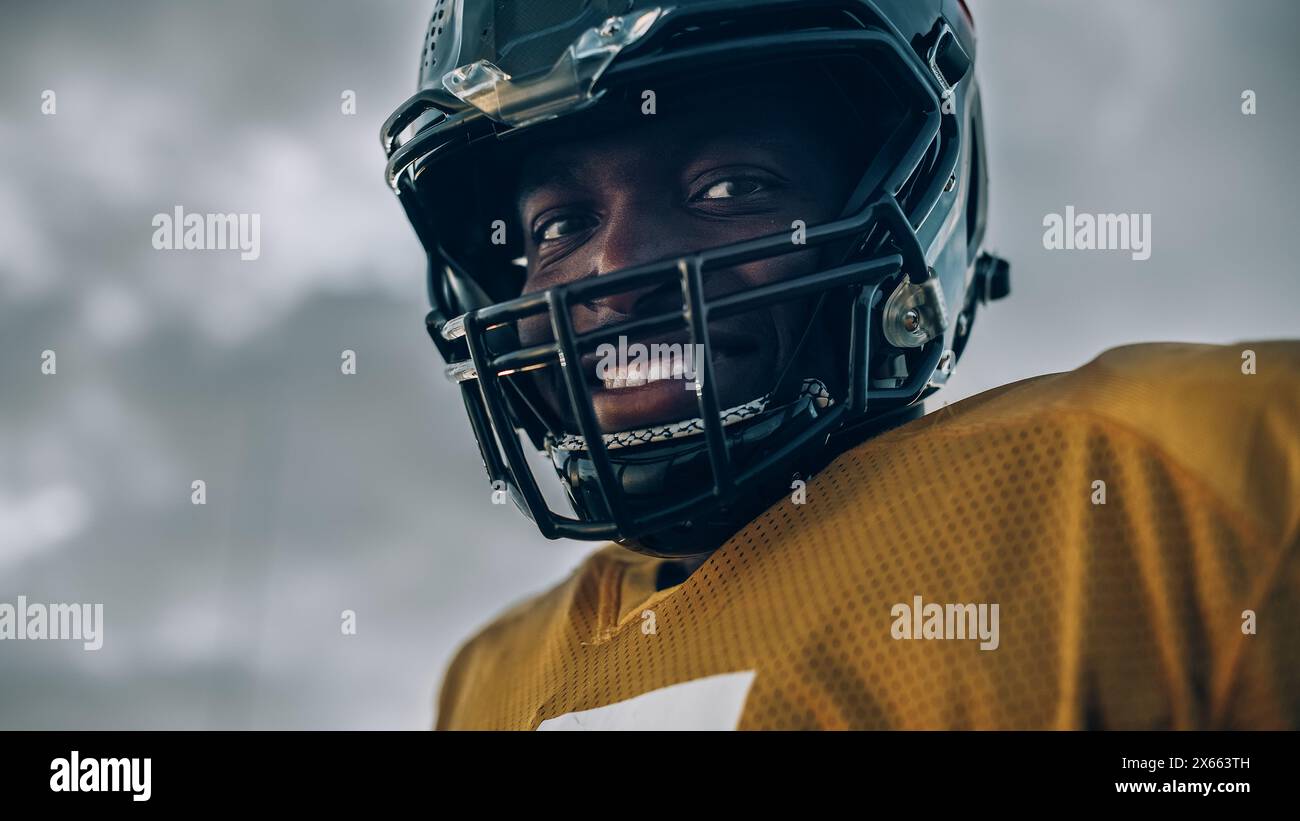 American Football Championship Game: Close-up Porträt des lächelnden professionellen Spielers mit Helm. Profi-Athlet voller Kraft, Geschick, Entschlossenheit zu gewinnen. Aufnahmen Mit Niedrigem Winkel Stockfoto