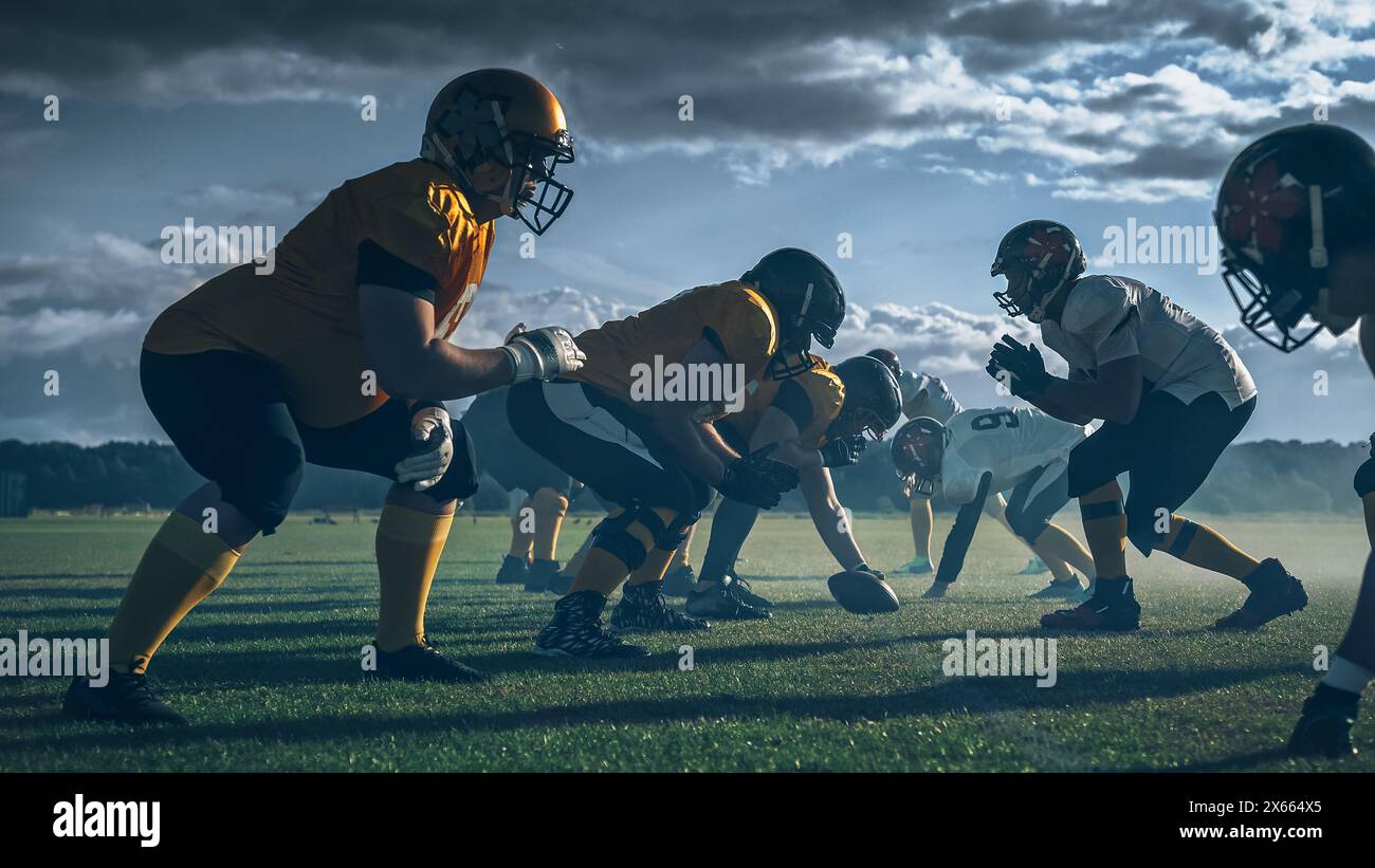 Zwei professionelle American Football-Teams stehen einander gegenüber und sind bereit, das Spiel zu starten. Verteidigung und Offensive bereite dich auf den Kampf um den Ball vor, mit dem Wunsch, Punkte zu sammeln und das Tor und den Sieg zu gewinnen. Stockfoto