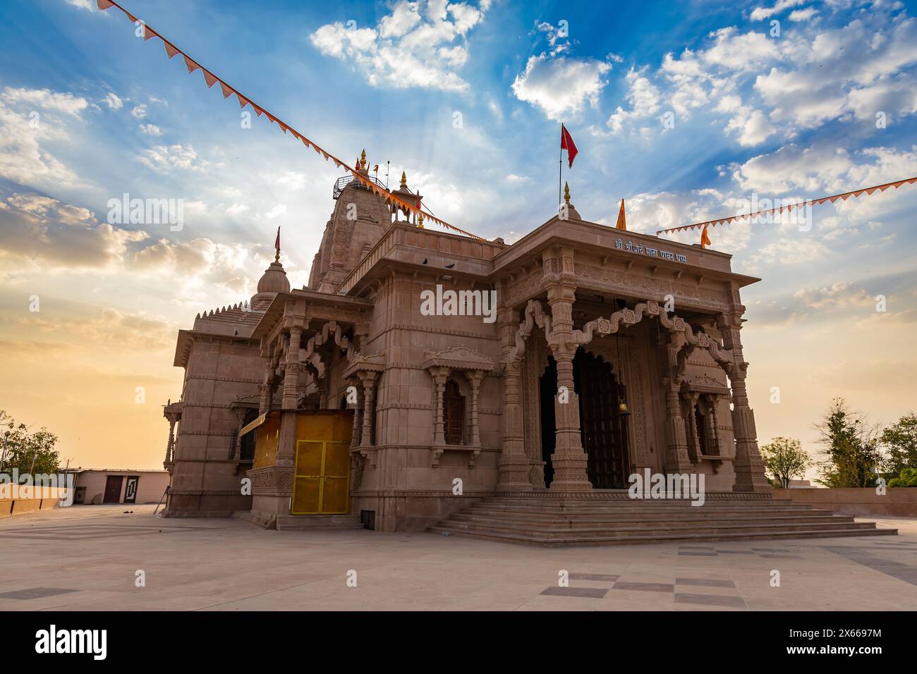 Künstlerischer hindu-Tempel mit dramatischem Sonnenuntergang am Abend aus einzigartiger Perspektive wird im Shri Yade Mata Pawan Dham Tempel jodhpur rajasthan aufgenommen Stockfoto