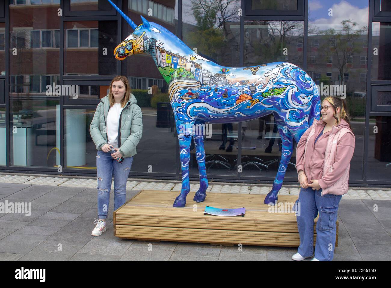 24. April 2024 zwei junge Studentinnen stehen kurz vor dem Ende ihres ersten Studienjahres neben der Skulptur Great Wave of Bristol Harbour auf Bristol Stockfoto