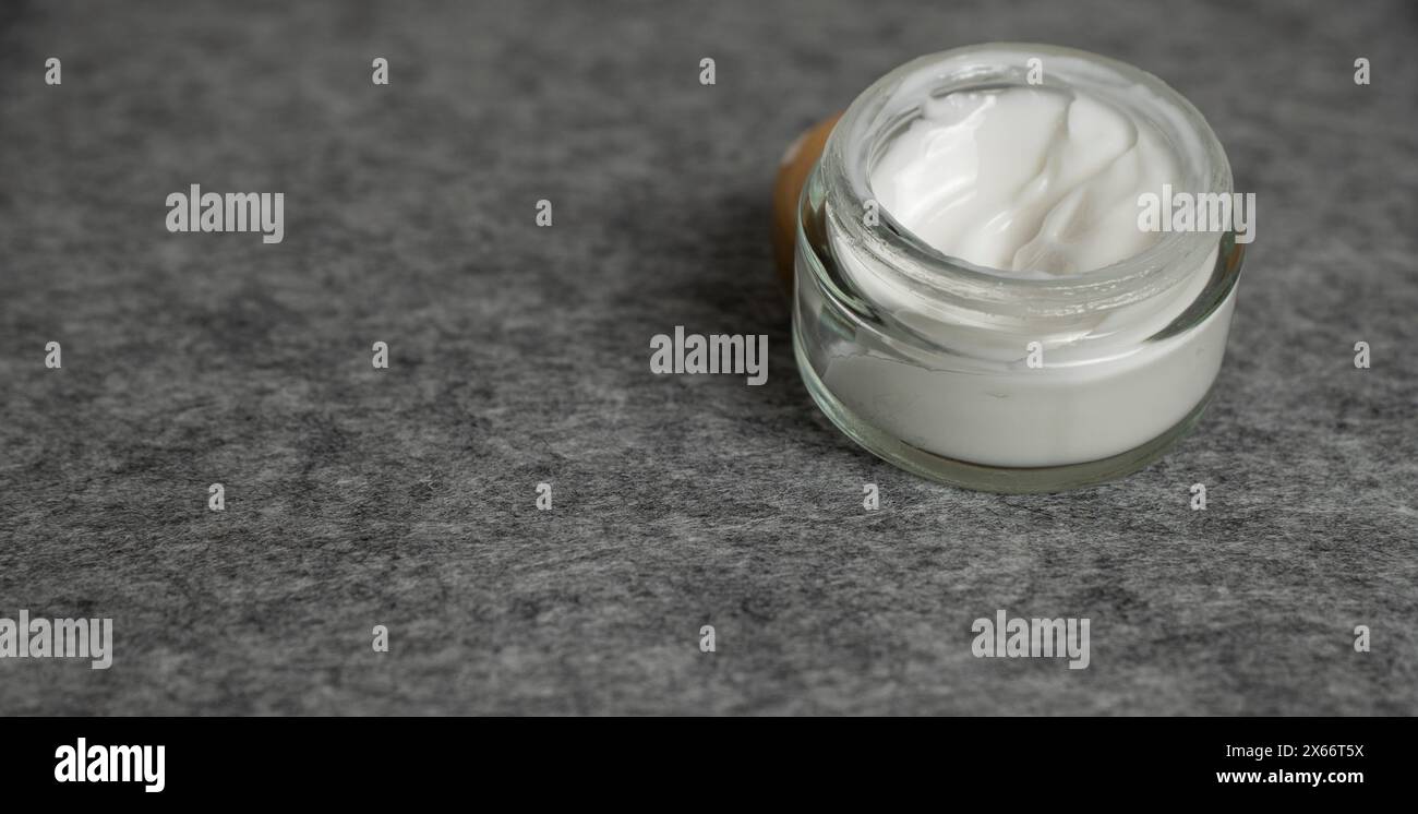 Hautpflegegefäß mit kosmetischer Anti-Aging-Creme auf grauer Oberfläche Stockfoto