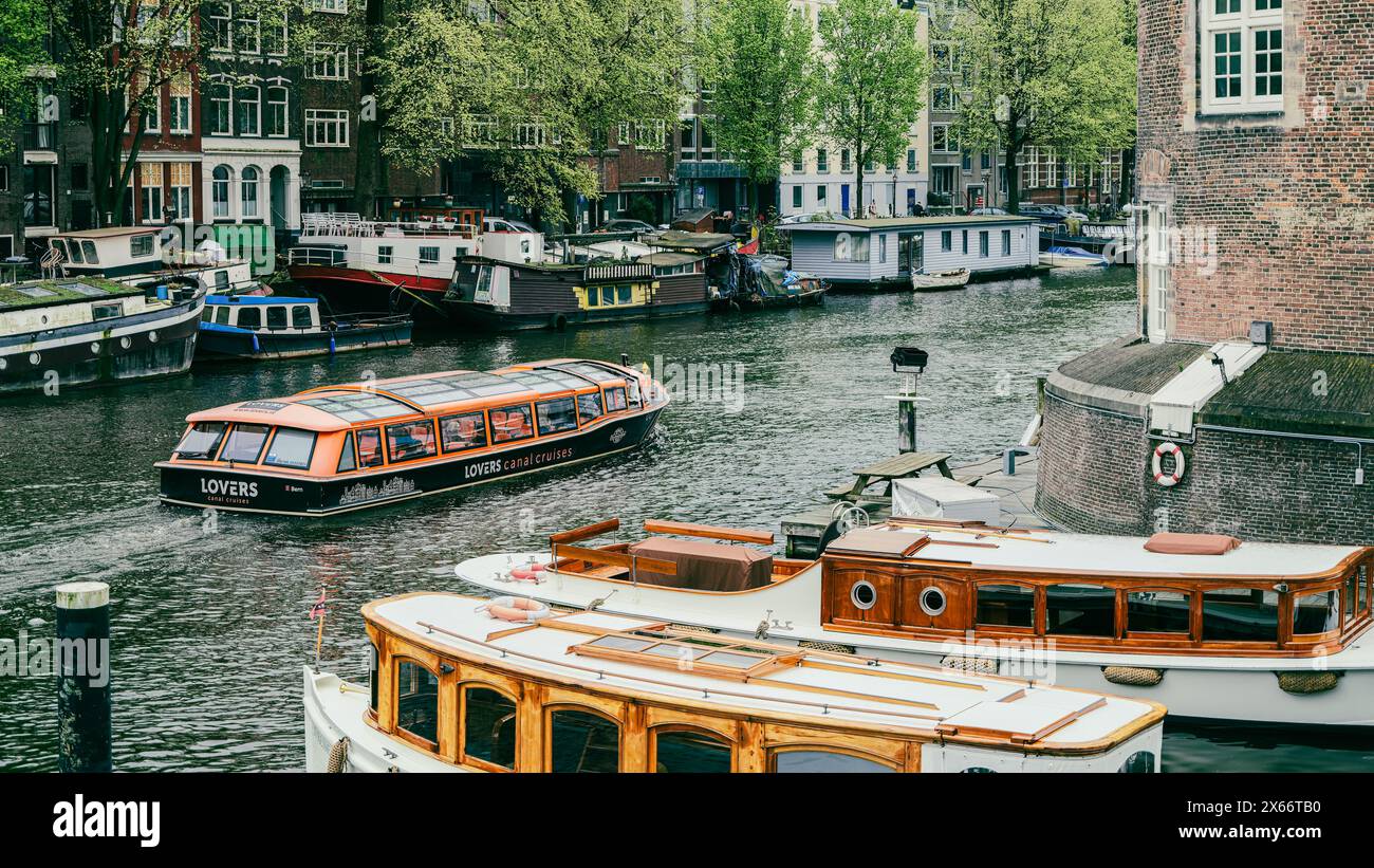 Nehmen Sie an einer Bootstour durch die berühmten Kanäle von Amsterdam Teil und genießen Sie die bezaubernde Architektur und die traditionellen Wege der niederländischen Kultur. Es ist wirklich ein Stockfoto