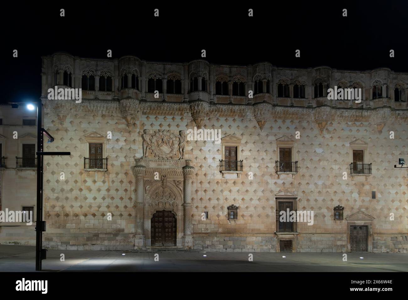 Historisches Gebäude bei Nacht, beleuchtet, mit großem Eingang und komplizierten architektonischen Entwürfen Stockfoto