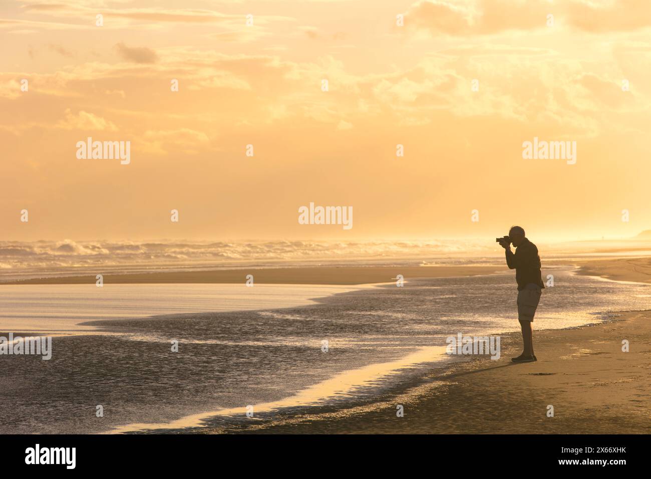 Ein Fotograf, der Fotos bei Sonnenuntergang entlang der argentinischen Atlantikküste in Orense, Argentinien macht. Stockfoto