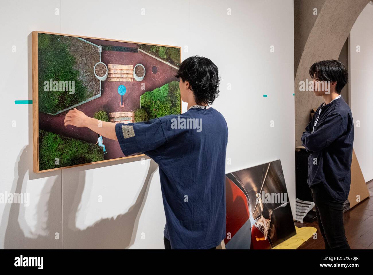 London, Großbritannien. 13. Mai 2024. Mitarbeiter am Stand der Egen Gallery Tokyo installieren Werke für die neunte Ausgabe von Photo London im Somerset House. Die jährlich stattfindende Fotomesse feiert die Fotografie vom Vintage bis zur Moderne zusammen mit einer Auswahl der weltweit führenden Fotohändler und Galerien. Vom 15. Bis 19. Mai findet ein öffentliches Programm mit Vorträgen, Touren und mehr statt. Quelle: Stephen Chung / Alamy Live News Stockfoto