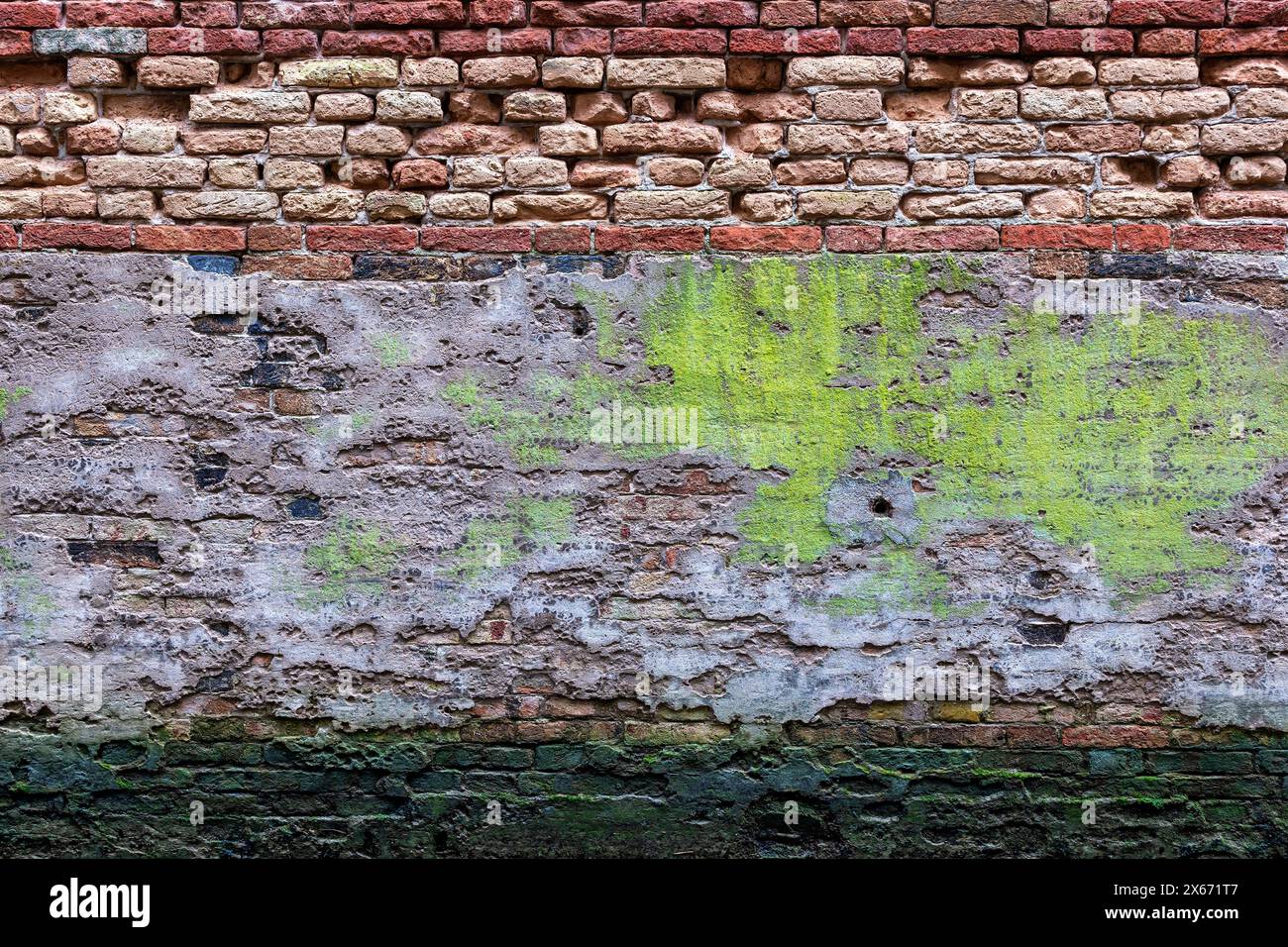 Alte verwitterte Wand Vintage Hintergrund des Venedig Kanal in Italien, Grunge aussehende Ziegelstruktur Textur mit abblätterndem Putz und Moos. Stockfoto