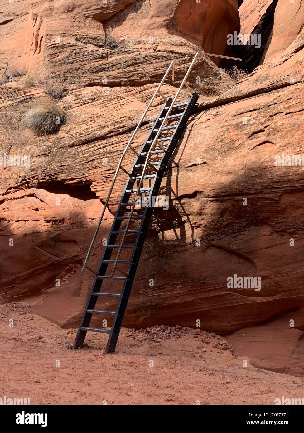 Die Navajo haben eine Leiter an der Seite eines Slot Canyon montiert, um Zugang zu den erstaunlichen Kammern auf der oberen Ebene zu ermöglichen, in denen wellenförmige Farben und Streifen ama sind Stockfoto