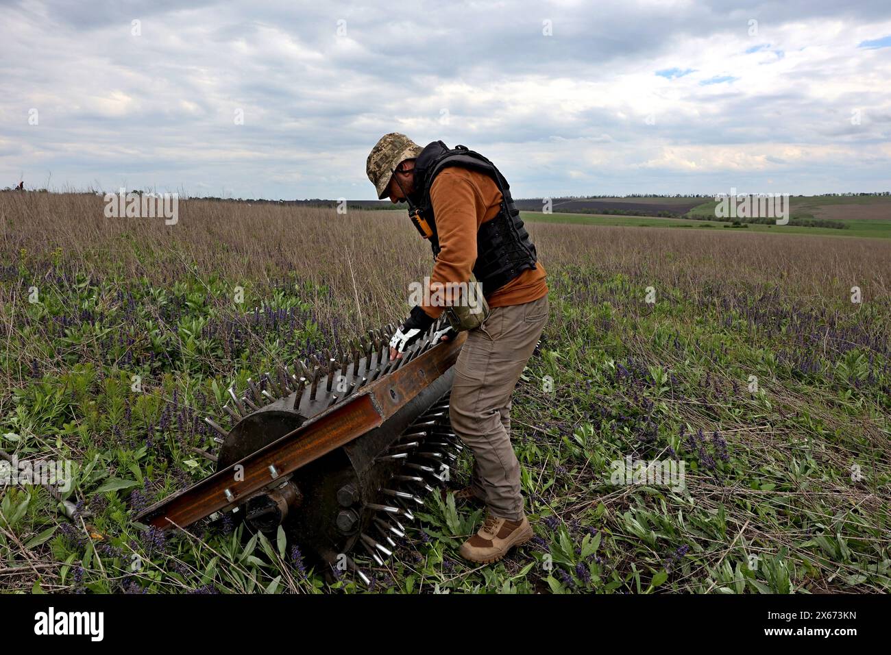 REGION CHARKIW, UKRAINE - 11. MAI 2024 - Ein Vertreter der NGO Demining of Ukraine räumt das Territorium eines landwirtschaftlichen Unternehmens von Sprengkörpern und den Folgen der Feindseligkeiten, Region Charkiw, Nordostukraine. Stockfoto