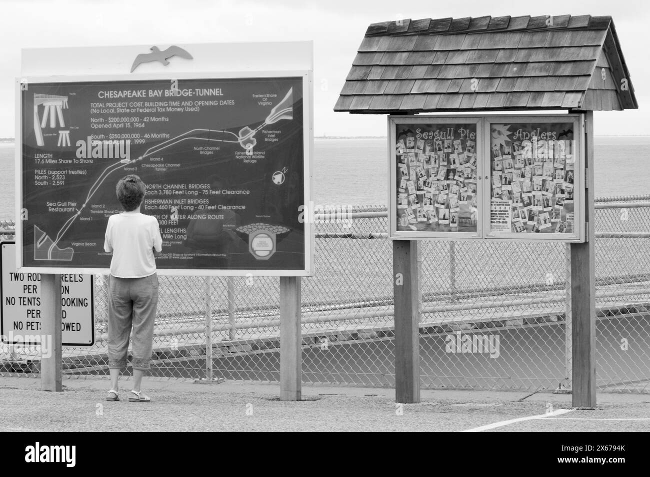 Frau liest Informationsschild an der Chesapeake Bay Bridge und Tunnel, Virginia, USA. Stockfoto