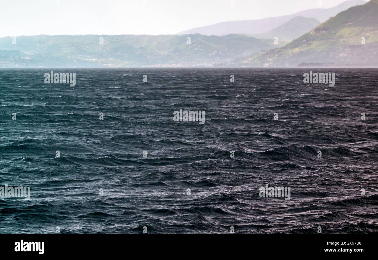 Wellen, die von herannahendem Sturm und Regen auf der Oberfläche des Gardasees gepeitscht werden Stockfoto