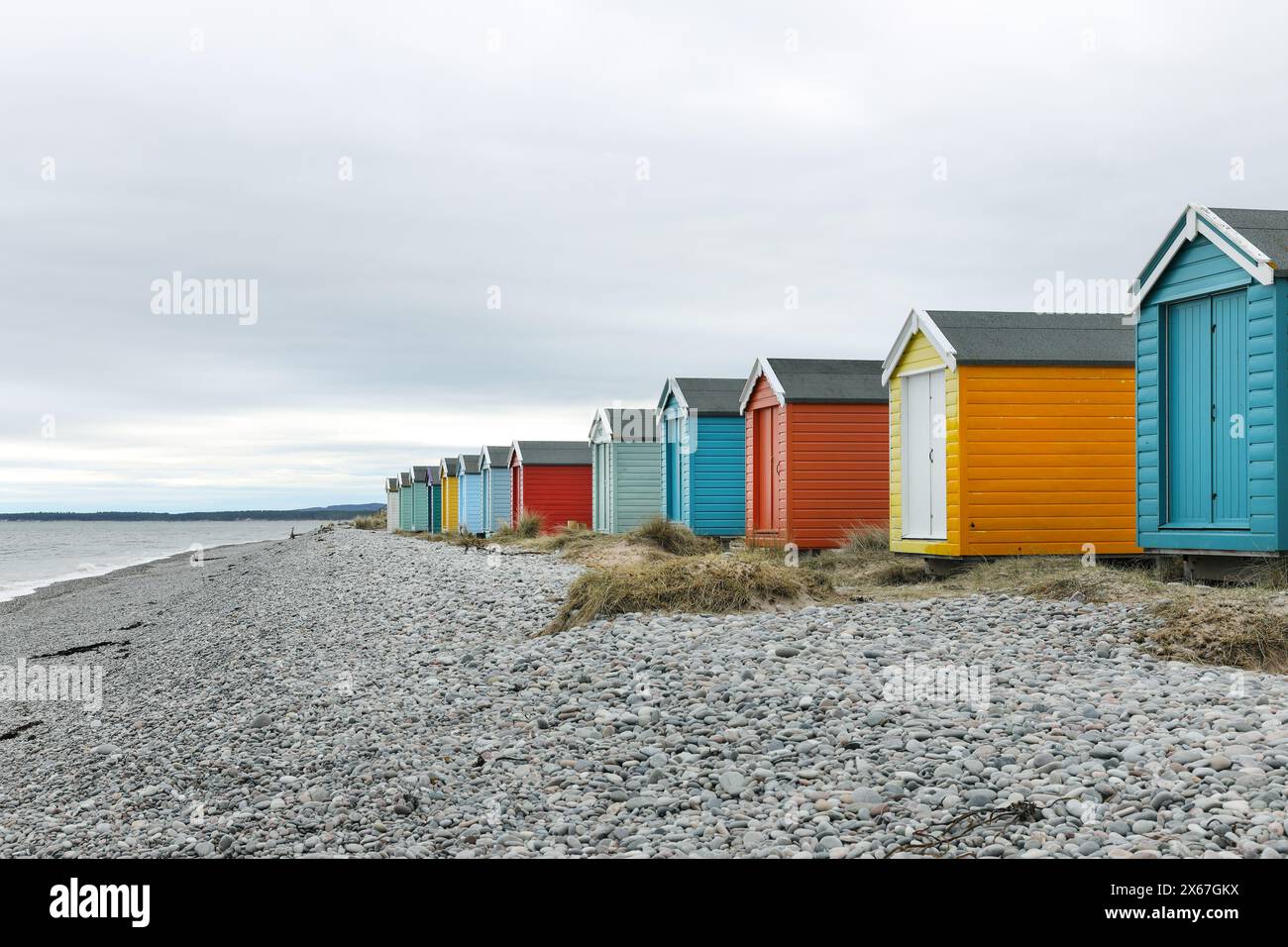 Farbenfrohe traditionelle Strandhütten an der Küste in Findhorn Bay, Moray Firth, Schottland, Großbritannien Stockfoto