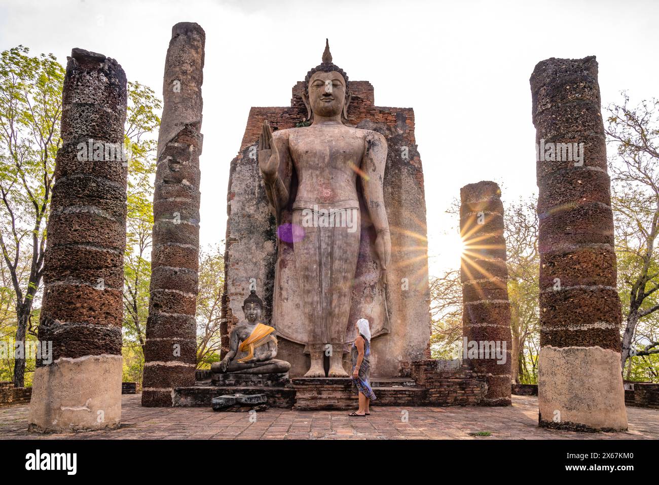 Tourist vor dem riesigen stehenden Buddha im Tempel Wat Saphan hin, UNESCO-Weltkulturerbe Sukhothai Historical Park, Thailand, Asien Stockfoto