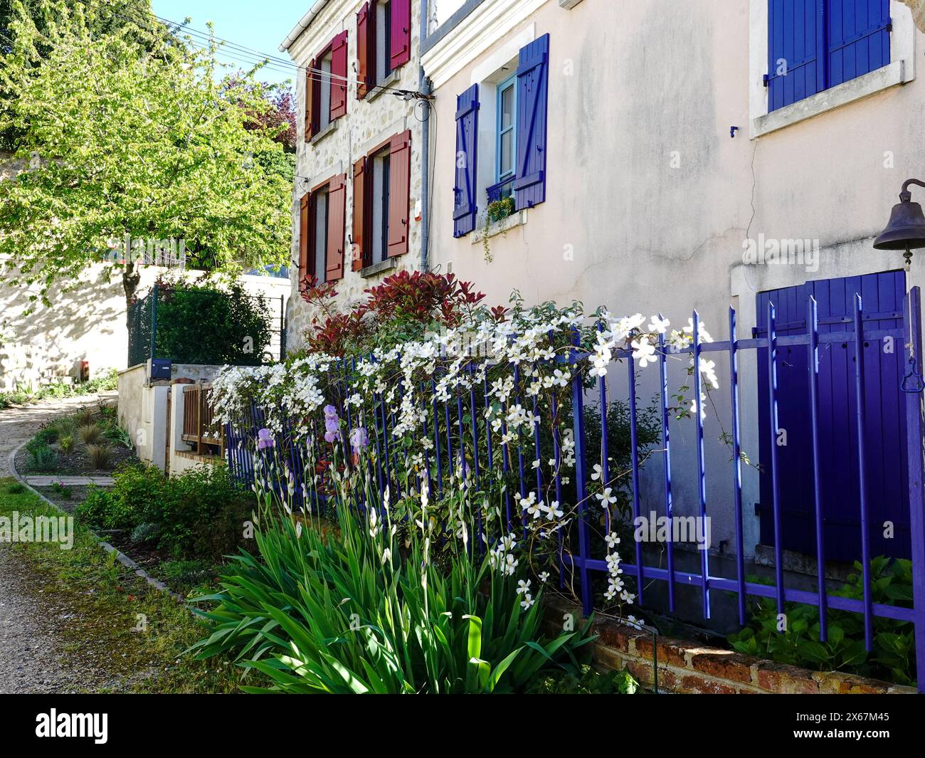 Wohngebäude mit bunten Fensterläden, Zaun und blühenden Blumen, in dem Dorf, in dem Van Gogh lebte und starb, Auvers-sur-Oise, Frankreich. Stockfoto