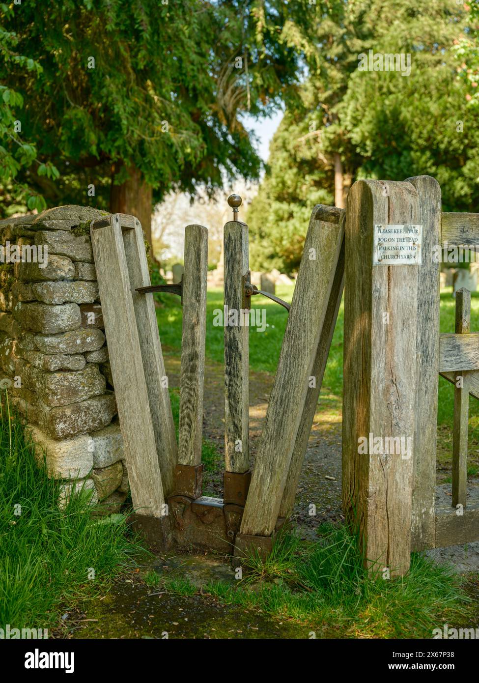 Das ungewöhnliche V-förmige, federbelastete Tor am Eingang zur Holy Cross Kirche im Dorf Ashton Keynes in Wiltshire. Stockfoto