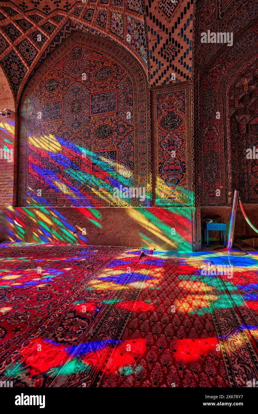 Ein Lichtspiel aus mehrfarbigen Buntglasfenstern in der Nasir al-Mulk Moschee aus dem 19. Jahrhundert, auch bekannt als die Rosa Moschee. Shiraz, Iran. Stockfoto