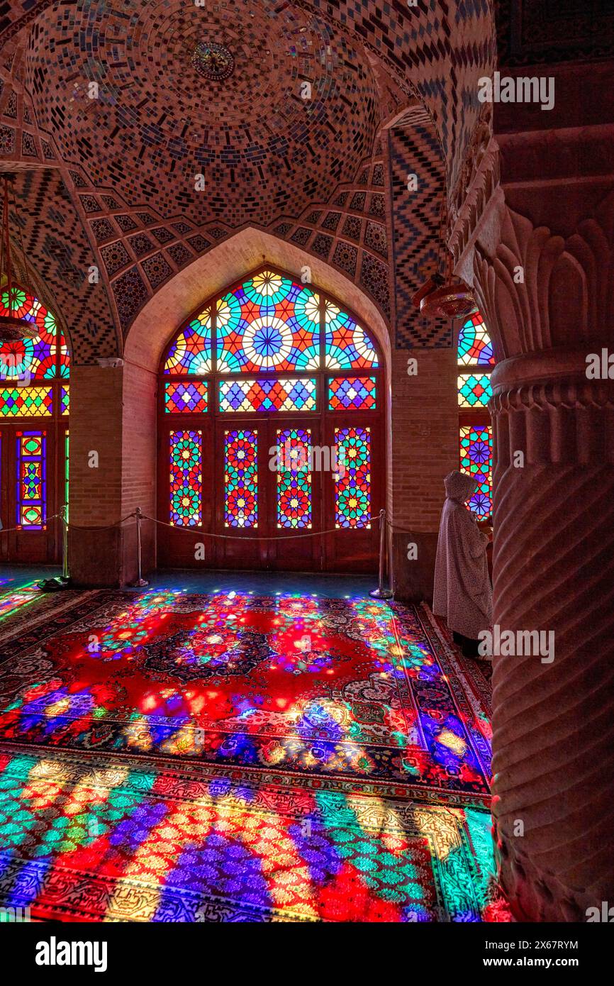 Ein Lichtspiel aus mehrfarbigen Buntglasfenstern auf Teppichboden in der Nasir al-Mulk-Moschee aus dem 19. Jahrhundert. Shiraz, Iran. Stockfoto