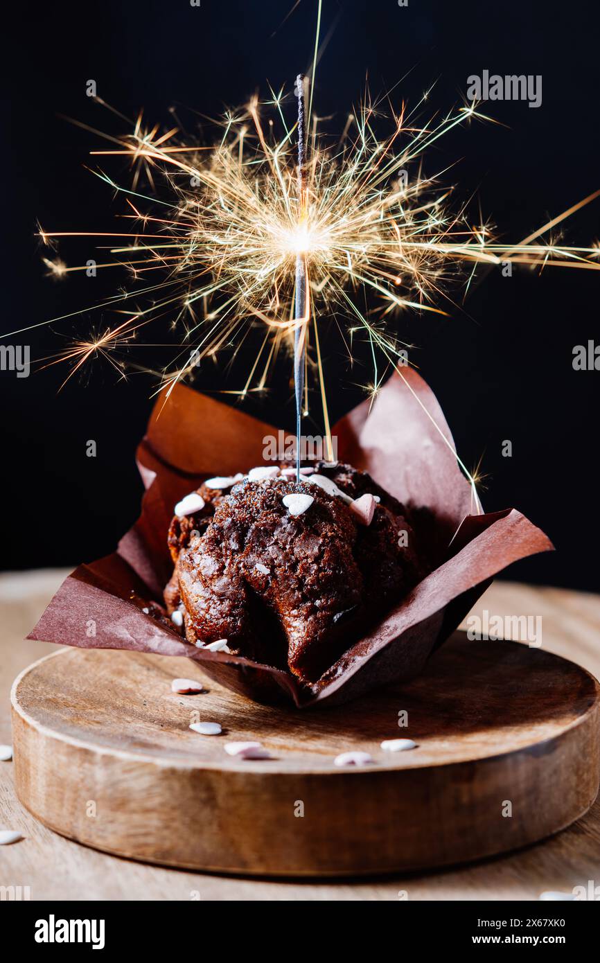 Festlicher Schokoladenmuffin mit Glitzer auf dunklem Hintergrund. Stockfoto
