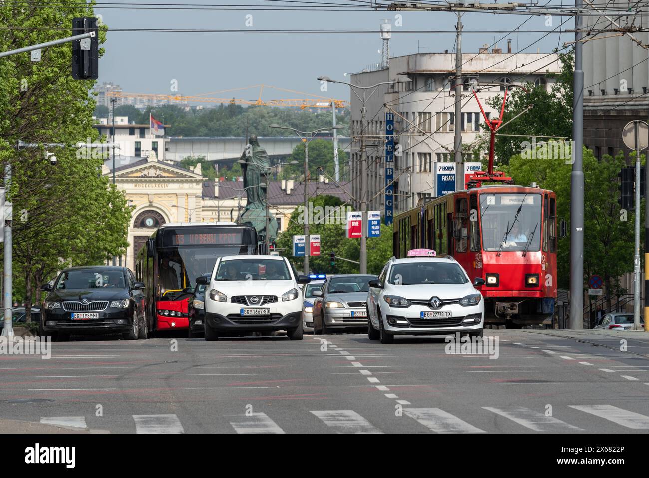 Der Verkehr reihte sich auf der Nemanjina Straße in Belgrad an. Auto, Taxi, Bus und Straßenbahn mit dem ehemaligen Bahnhof in der Ferne. Mai 2024. Stockfoto