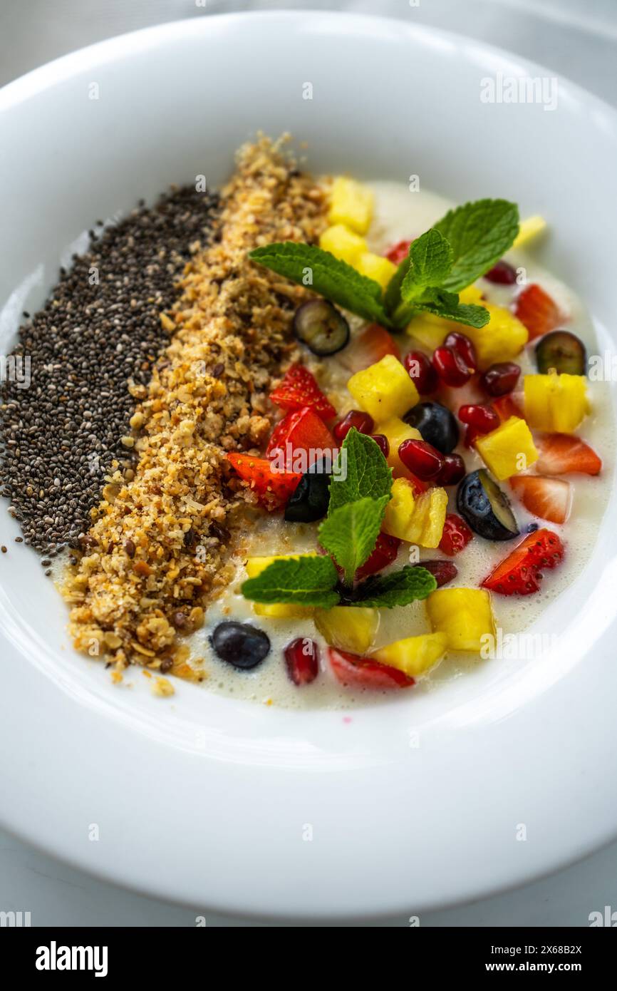 Gesunde Frühstückschüssel, frisches Obst und Beeren, Chia Samen, Müsli, Smoothie Bowl auf einem Tisch Stockfoto