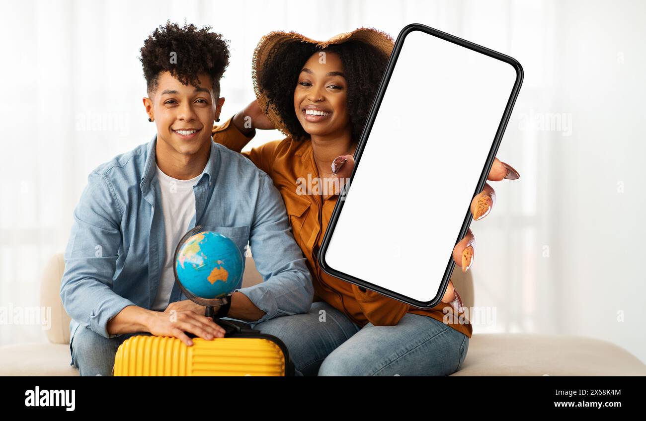 Junges Paar bereit für Abenteuer mit Smartphone mit leerem Bildschirm Stockfoto
