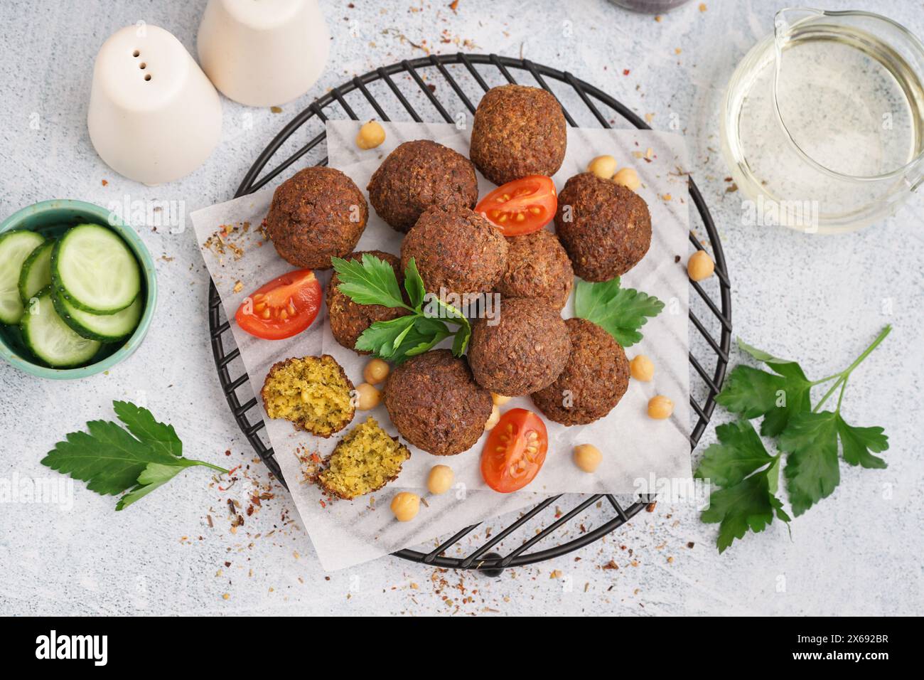 Stehen Sie mit köstlichen Falafelbällchen, Kichererbsen und Tomaten auf hellem Hintergrund Stockfoto