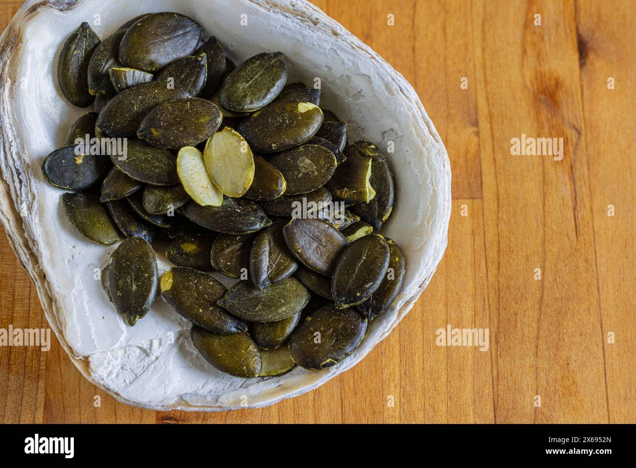 Kürbiskerne, Muschelschale als Schüssel, Stillleben Stockfoto