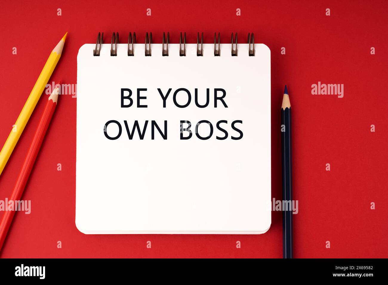 Text „Be your own Boss“ auf rotem Hintergrund des Notizblocks Stockfoto