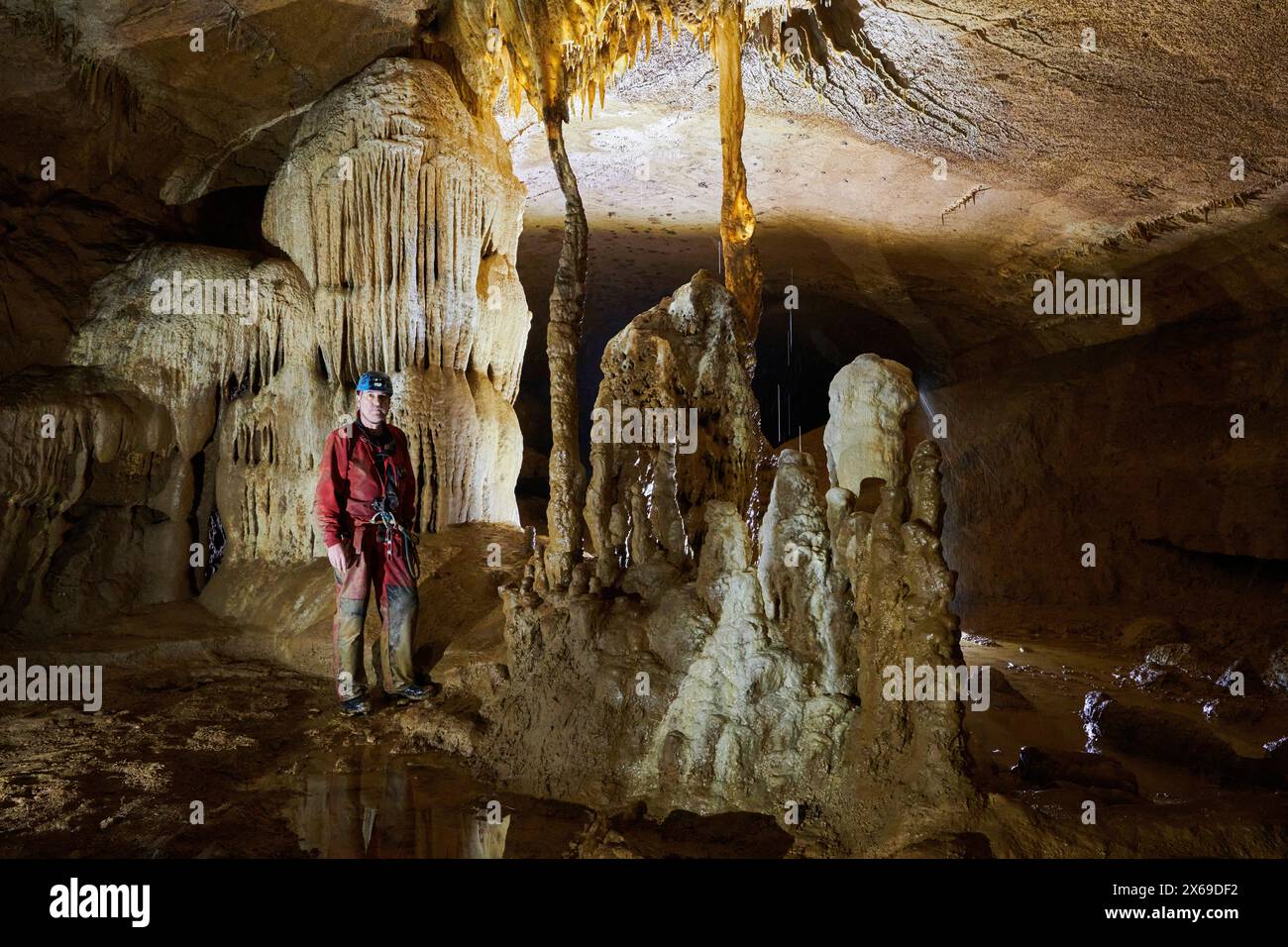Speläologe in einer Höhle, Wassertropfen fallen von der Decke Stockfoto