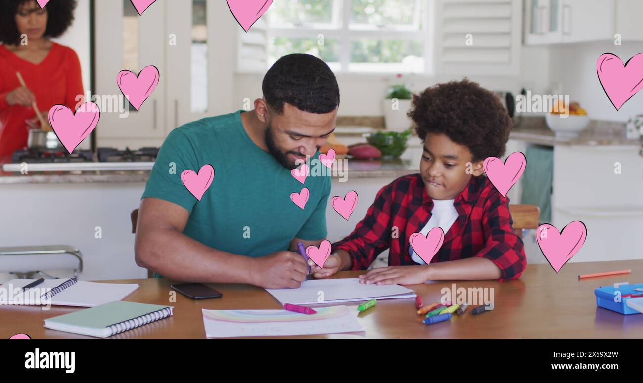 Bild von Social-Media-Herzsymbolen über lächelnden Menschen und Sohn, die Hausaufgaben machen Stockfoto
