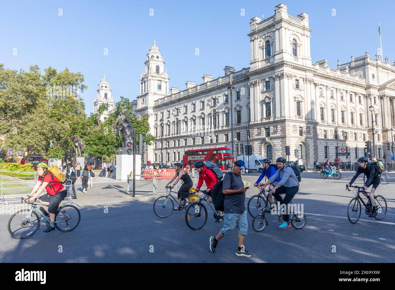 Fahrradfahren in London, Radfahrer fahren auf dem Parliament Square Westminster Central London am sonnigen Herbstmontag am blauen Himmel, England, UK, 2023 Stockfoto