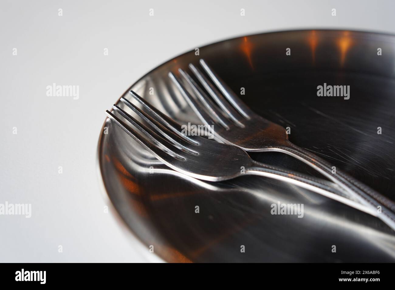 Edelstahlplatte und Gabel auf weißem Tisch Stockfoto