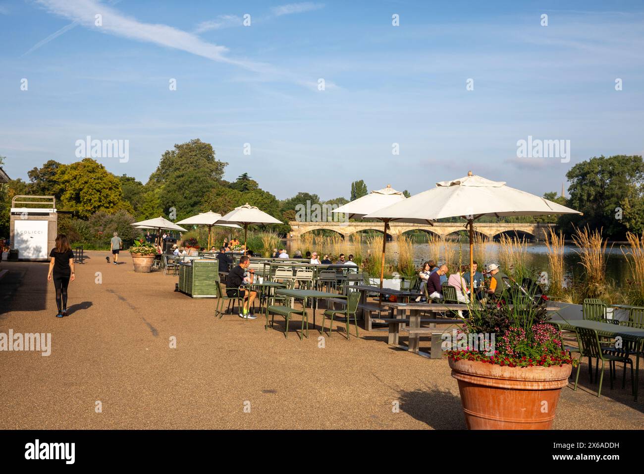 Hyde Park London das Serpentine lido Café am sonnigen September Morgen mit Blick auf den See und Serpentine Bridge für Gäste, London, England, UK, 2023 Stockfoto