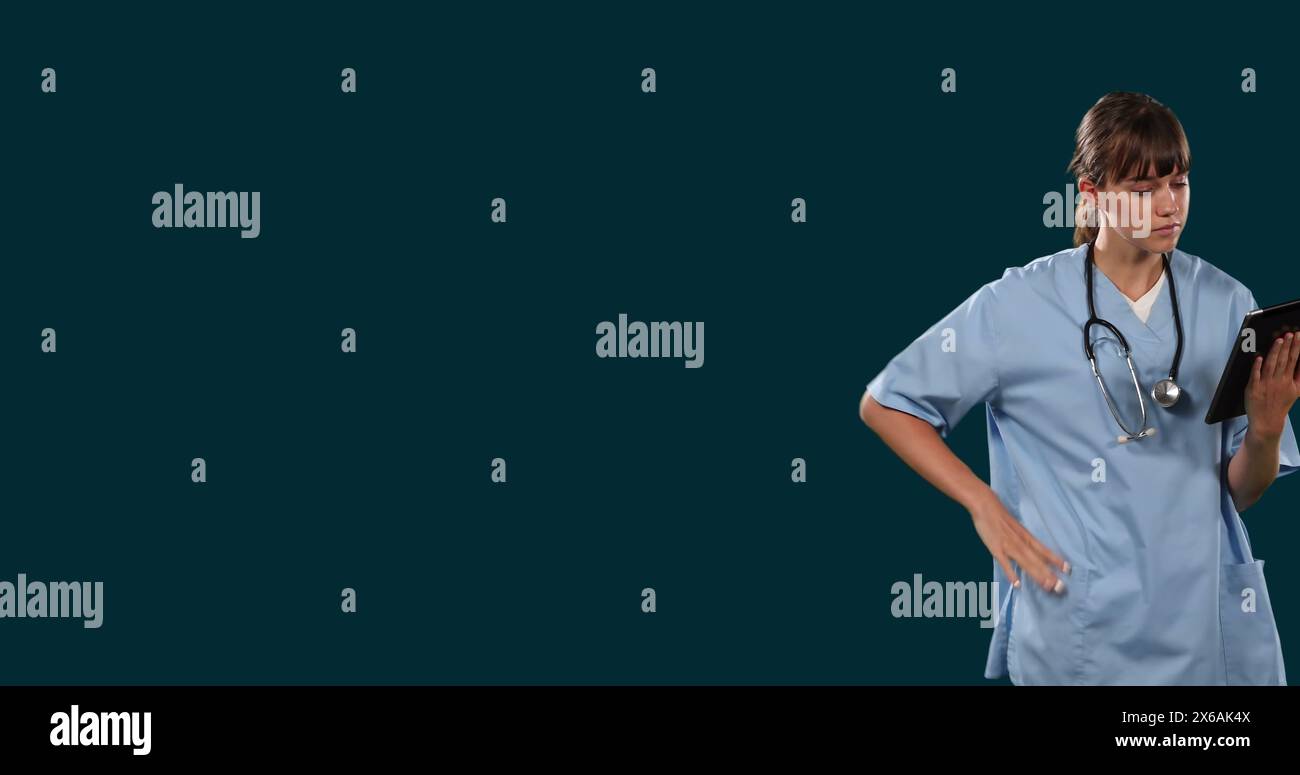 Bild einer nachdenklichen kaukasierin, die auf einem digitalen Tablet vor schwarzem Hintergrund surft Stockfoto