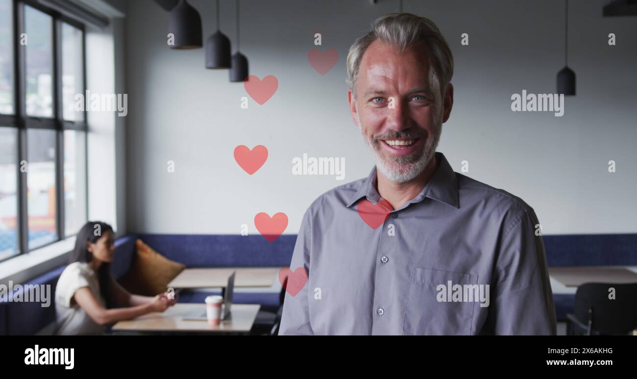 Kaukasischer Manager, graues Hemd und rote Krawatte, lächelnd in einem Café Stockfoto