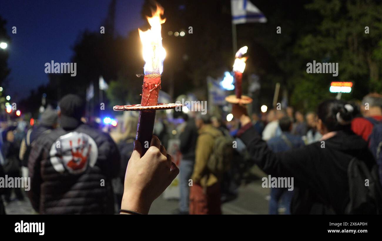 JERUSALEM - 13. MAI: Demonstranten halten Flammenfackeln, während sie an einer Demonstration in der Nähe des Privatsitzes von Premierminister Netanjahu teilnehmen, die die Freilassung israelischer Geiseln im Gazastreifen fordert, und gegen den israelischen Premierminister Benjamin Netanjahu und seine Regierung am 13. Mai 2024 in Jerusalem. Israel Stockfoto