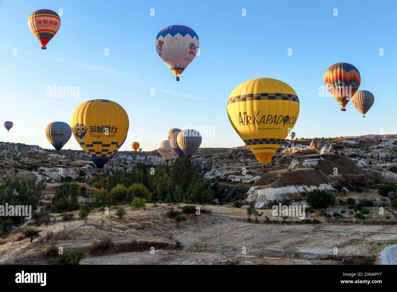 GOREME, TÜRKEI - 4. OKTOBER 2020: Dies ist eine Gruppe von tief fliegenden Ballonen über der Oberfläche der Täler Kappadokiens am frühen Morgen. Stockfoto