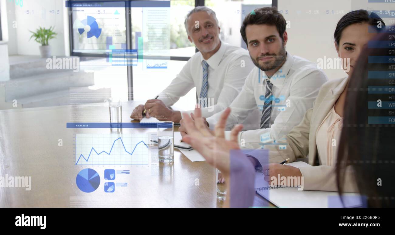 Kaukasische Kollegen, zwei junge und ein Mann mittleren Alters, diskutieren Daten auf einem klaren Bildschirm Stockfoto