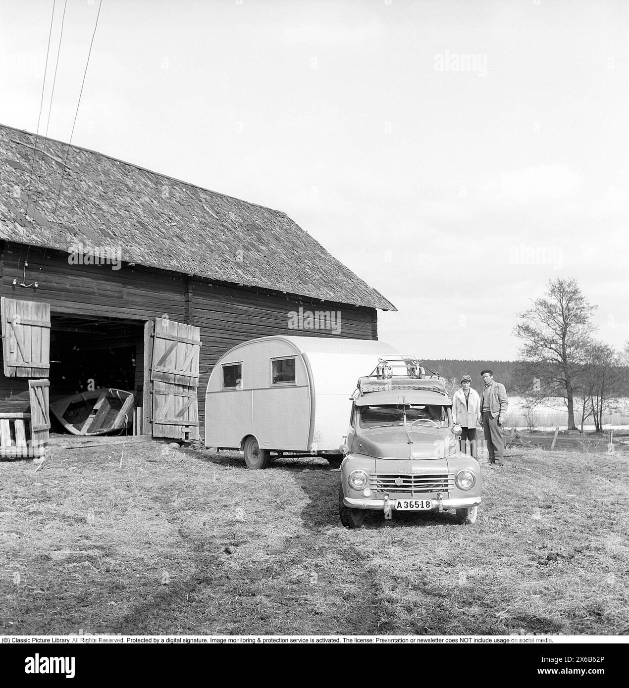 Caravan in den 1950ern Eine Familie hat ihren Wohnwagen im Winter in der Scheune geparkt und es ist an der Zeit, den Wohnwagen für den Sommerurlaub zu nutzen. Das Auto ist ein Volvo PV. Conard Ref. 3722 *** örtlicher Bildtitel *** Husvagnen kan vara föregångaren till husvagnen Ägget som lanserades 1955. DET första beispiellaret av den husvagnen byggdes 1948 byggdes på initiativ av Helmer Berglund i Örebro på hans eget företag SMV, Sörby Mekaniska Verkstad. Han och hustrun kunde inte enas om hur de Skulle fira sin Semester men han bestämde sig för att göra en husvagn. EN kompromiss mellan fruns önskan om en Stockfoto